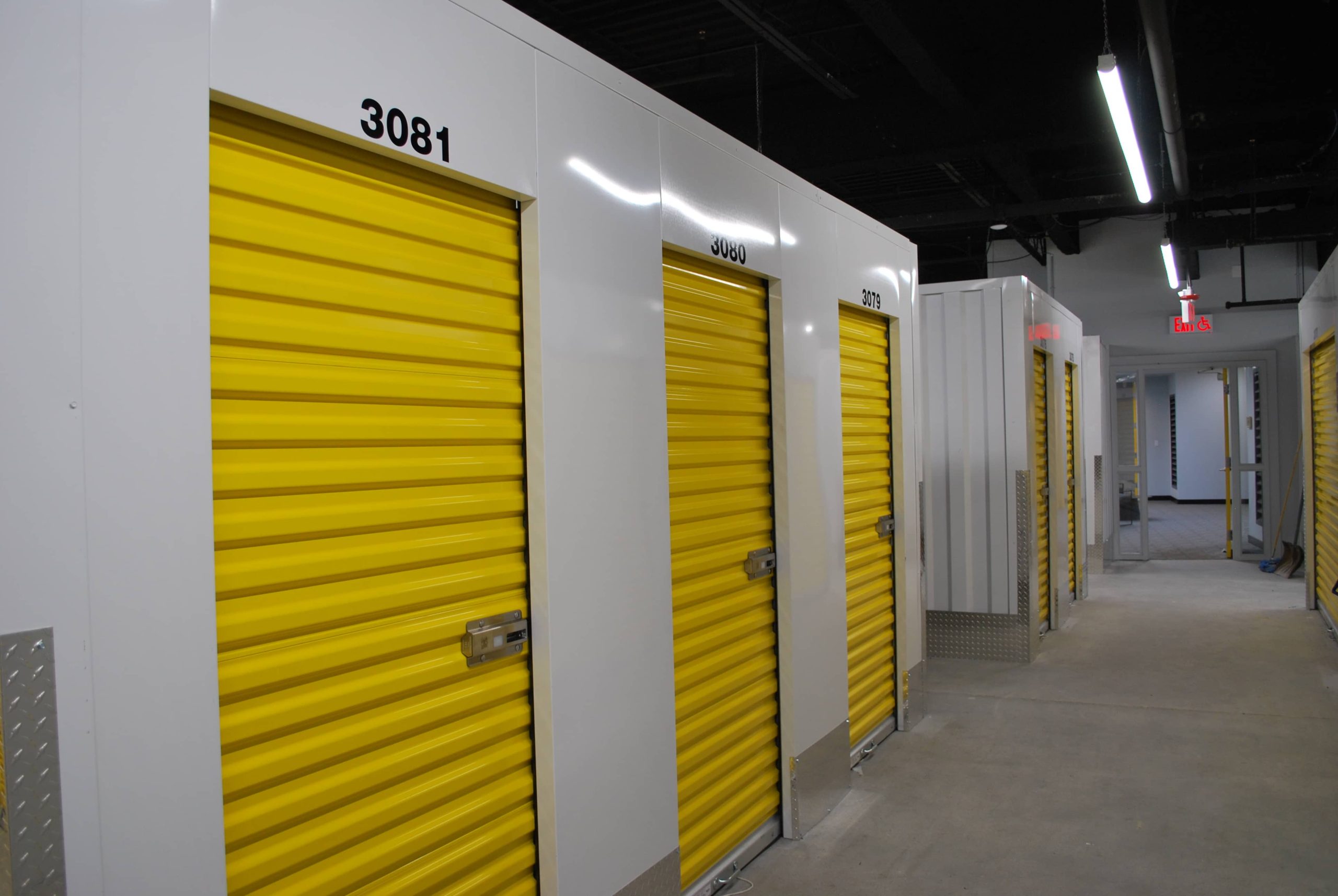 Row of indoor storage units with yellow roll up doors