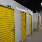 Row of indoor storage units with yellow roll up doors