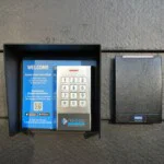 Keypad to enter to the facility with a blue poster that states the steps on how to use the keypad
