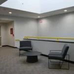 Seating area with two grey modern styled lounge chairs around a black metal round table