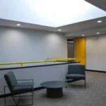 Seating area with two grey modern styled lounge chairs around a black metal round table